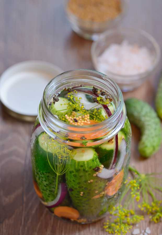 Pickled cucumbers, homemade preserved on wooden table