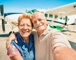 A retired couple taking a selfie on the beach. 